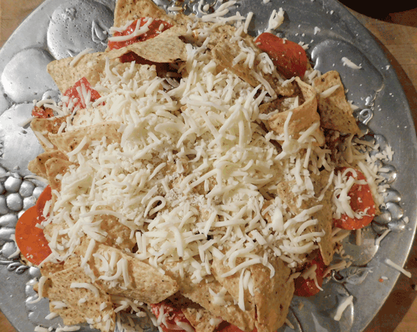 Chips, cheese and pepperoni on silver platter