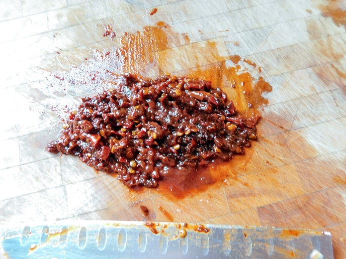 Finely chopped chipotle prppers on a chopping block