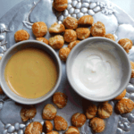 Soft pretzel bites on a silver platter with honey mustard and horsradish dipping sauce in white bowls