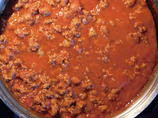 Cooked sausgae in marinara sauce in skillet