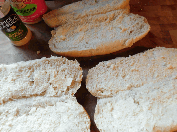 Split Hoagie buns spread with butter and parmesan cheese