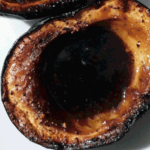 Close up of one side of an acorn squash roasted with brown sugar syrup in the middle