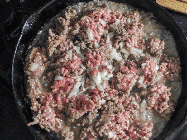 Cooking ground beef and onions in a cast iron skillet