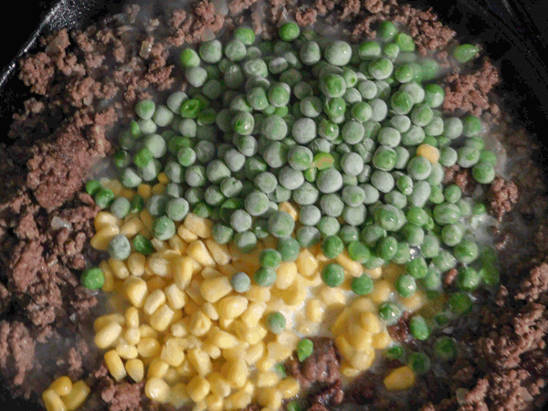Cooked ground beef with frozen peas and corn