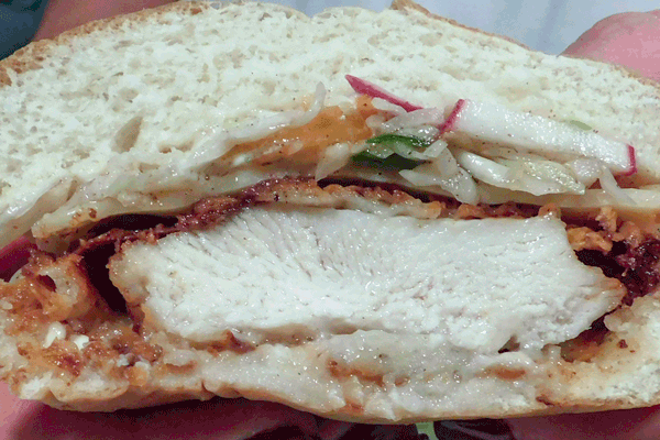 Cross section of fried chicken sandwich with colesalw