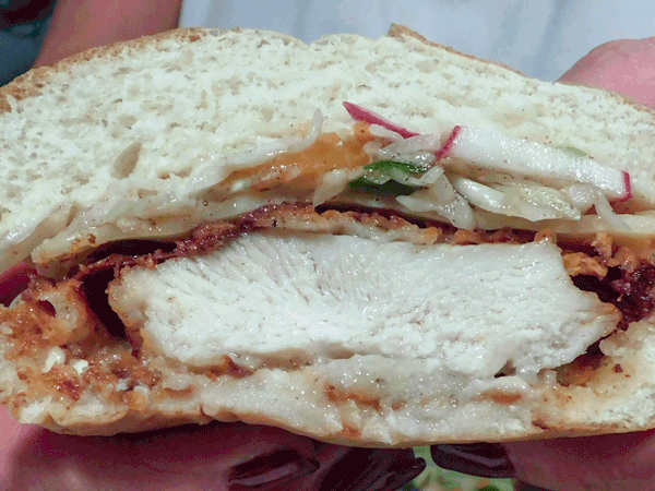 Cross section of fried chicken sandwich with colesalw