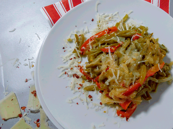green beans, red peppers, with melted parm on a white plate
