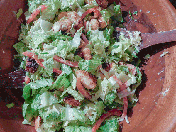 Cornbread croutons in a salad in a wooden bowl