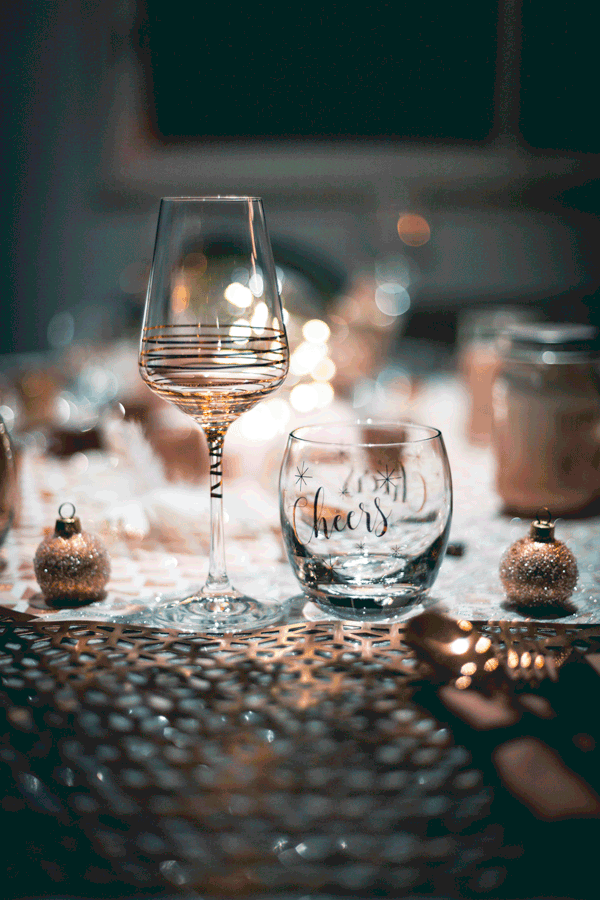 Glasses on a table - with Cheers written on one. 