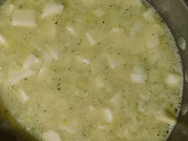 Cut Potatoes covered with chicken soup base in soup pot