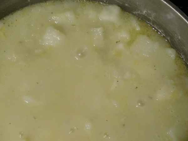 Cooked potatoes in chicken broth in a soup pot