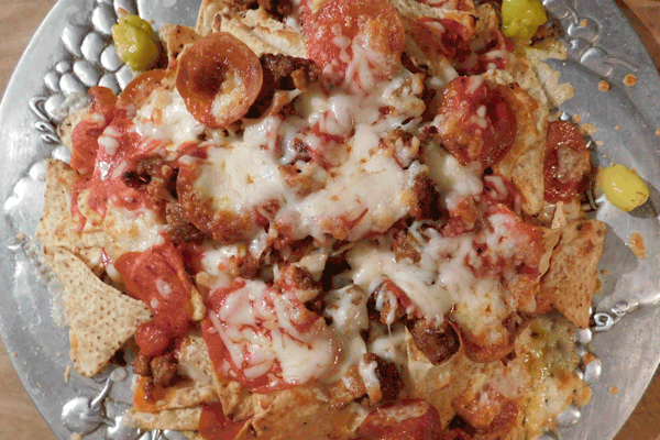cooked pizza nachos on silver platter
