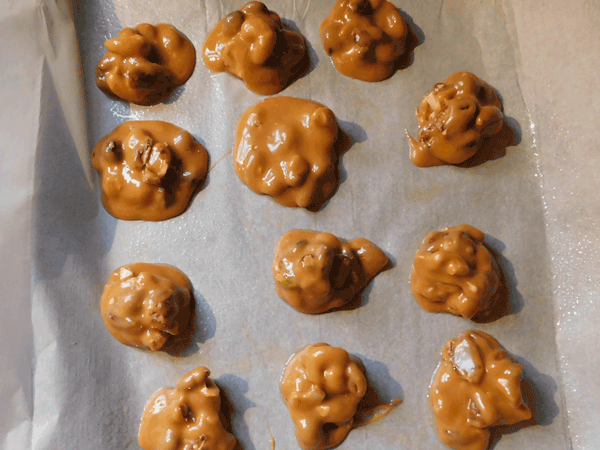Scooped Caramel with mixed nuts inside on baking sheet