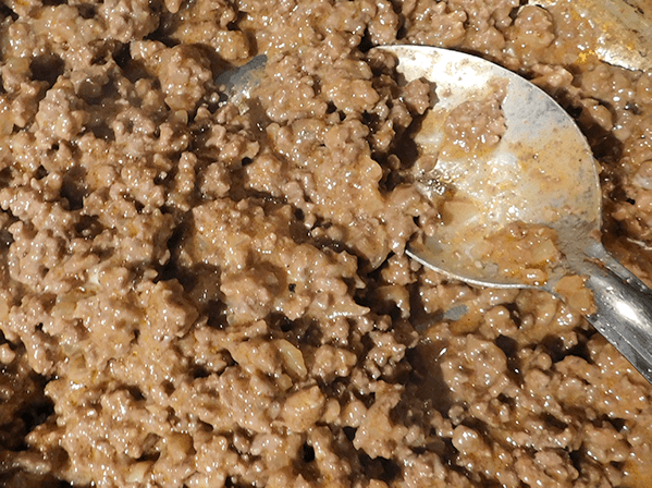 creamy cheesy cooked ground beef with a silver spoon