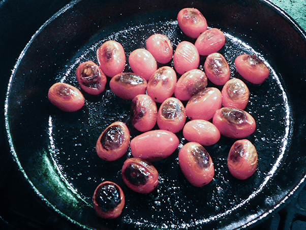 Charred tomatoes in a cast iron skillet