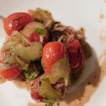 Charreed grape tomatoes, red onion and celery on a white plate
