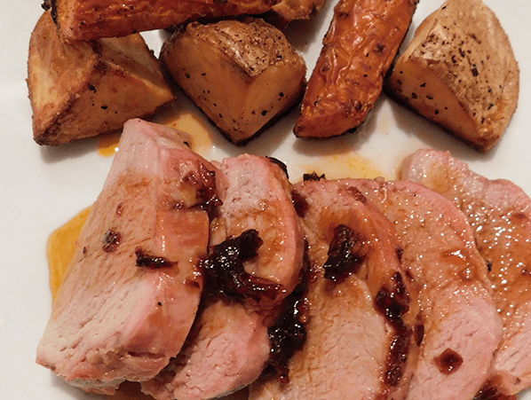 Pork Tenderloin with maple chipotle glaze and roasted potatoes on a white plate