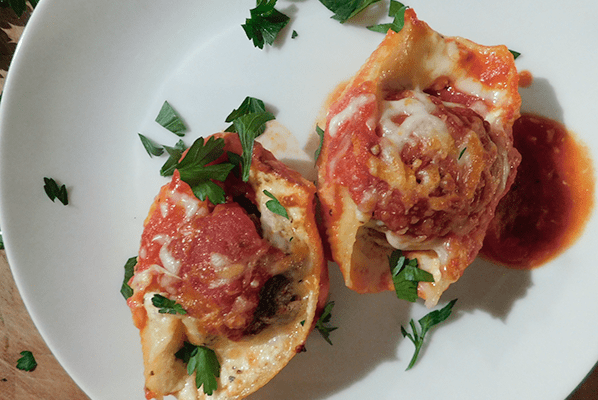 Two double stuffed shells on a white plate