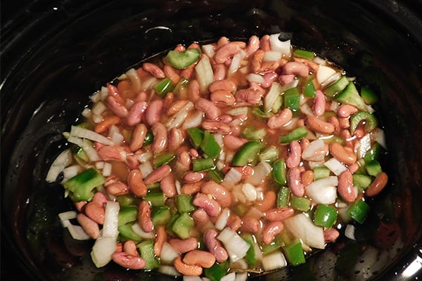 Soaked red beans with the fixings covered with water and stirred