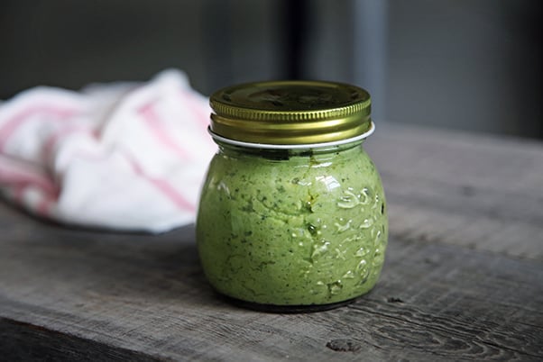 Mashed green vegetables in a mason jar on a wooden surface