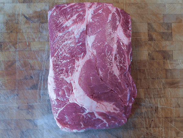 Beef chuck roast on a chopping block