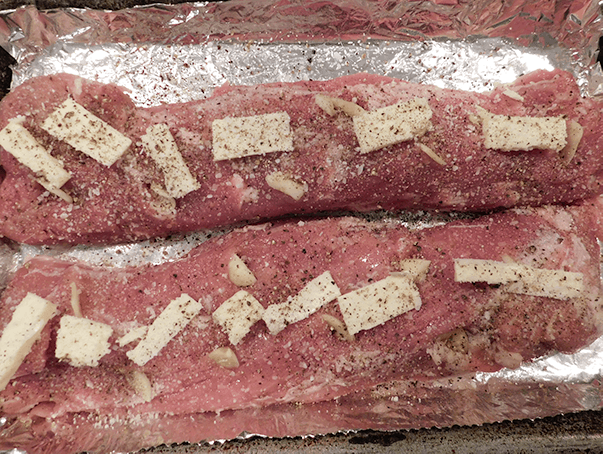 Close up of salted and peppered tenderloin dotted with butter