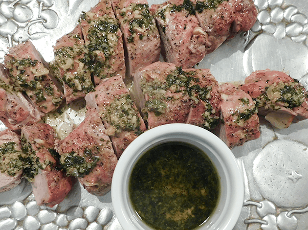 Cooked pork tenerloin with sauce on a silver platter