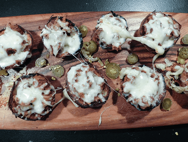 Cooked Brisket Potato Skins on a little paddle shaped serving plate
