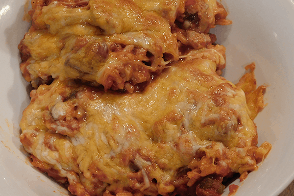 Prepared Tex-Mex sausage skillet in a white bowl oozing with cheese