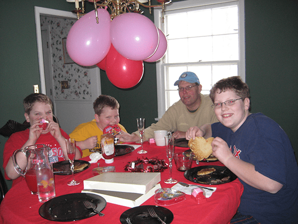 Three boys and Dad around dining room table eating special breakfast