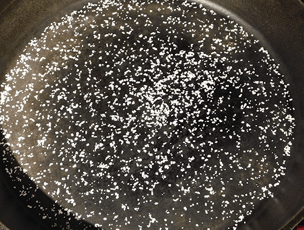 Cast iron skillet with kosher salt sprinkled across