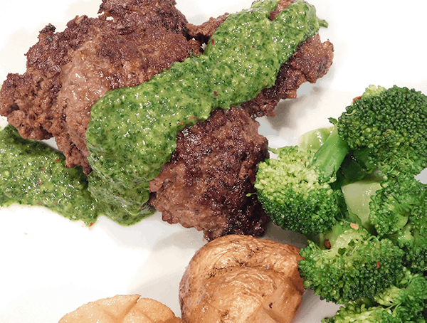 Chimichurri Sauce coating chopped steak on a white plate