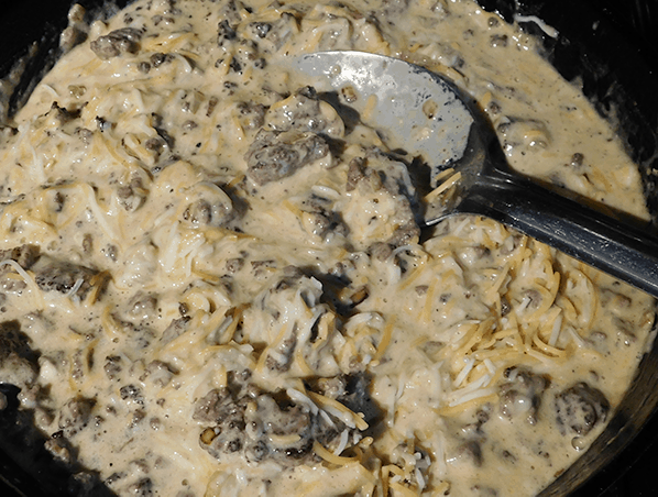 Cooked ground beef, cream, eggs and cheese ready for the oven to make cheeseburger pie