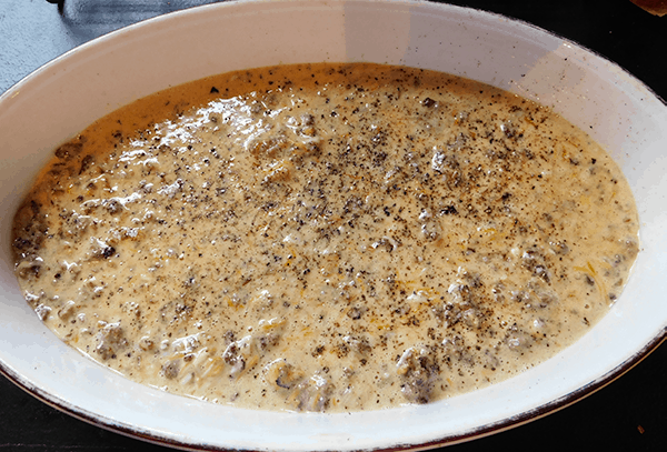 Uncooked cheeseburger pie in a white casserole dish ready for the oven