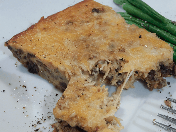 Melty cheeseburger pie on a white plate ready to eat