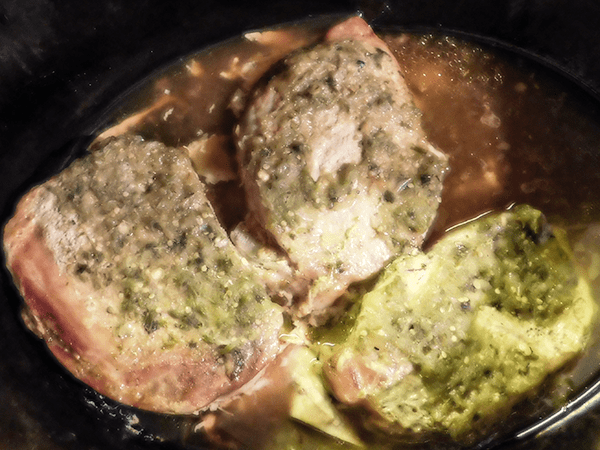 Cooked Pork Chops in crock pot with salsa verde on top