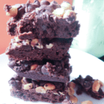 Stack of brownies with peanuts and chocolate chips on the top