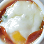 Closeup of baked egg in white ramekin