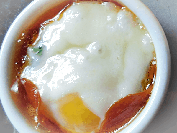 Closeup of baked egg in white ramekin