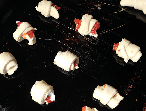 Cheesy Jelly Bites rolled up on baking sheet ready to cook