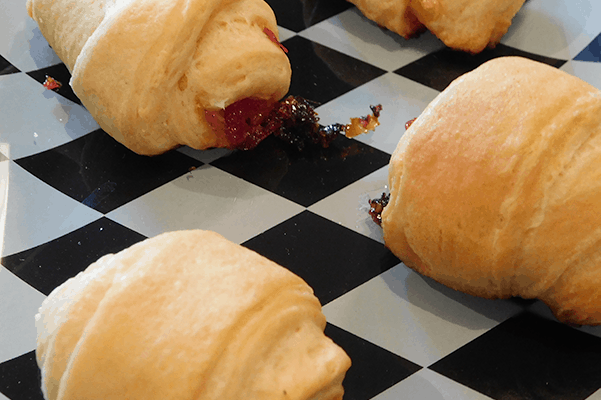 Cooked Cheesy Jelly Botes on black and white checker board pattern platter