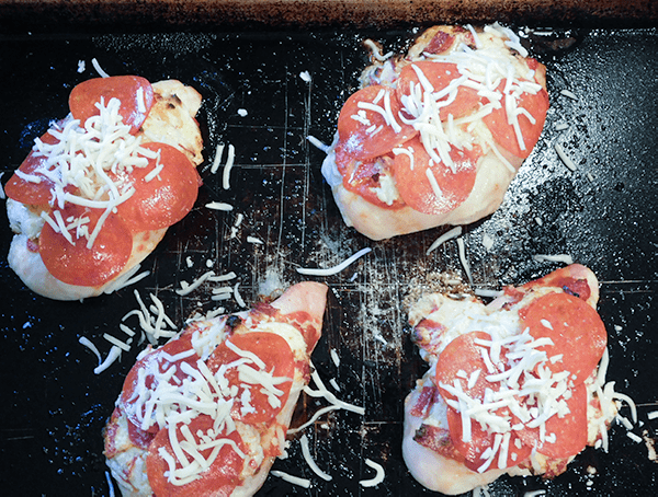 Partially cooked Pepperoni Pizza Chicken gout of the oven and covered with more pepperoni and cheese