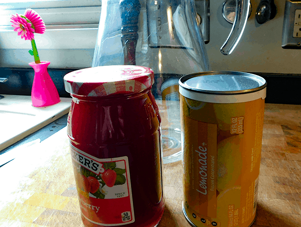 Strawberry preserves and frozen concentrated lemonade on chopping block