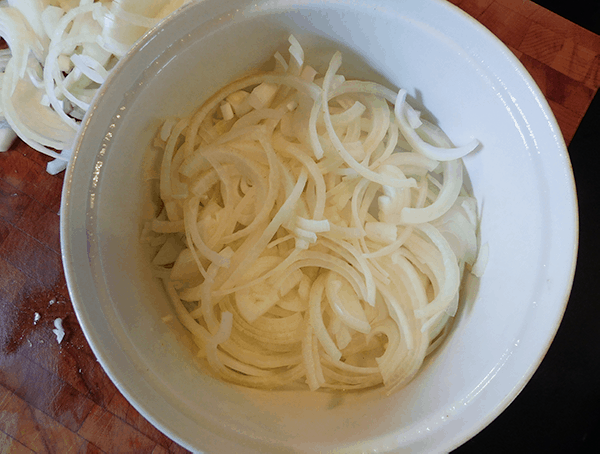 Onions sliced in casserole dish ready to cook into Scalloped Onions