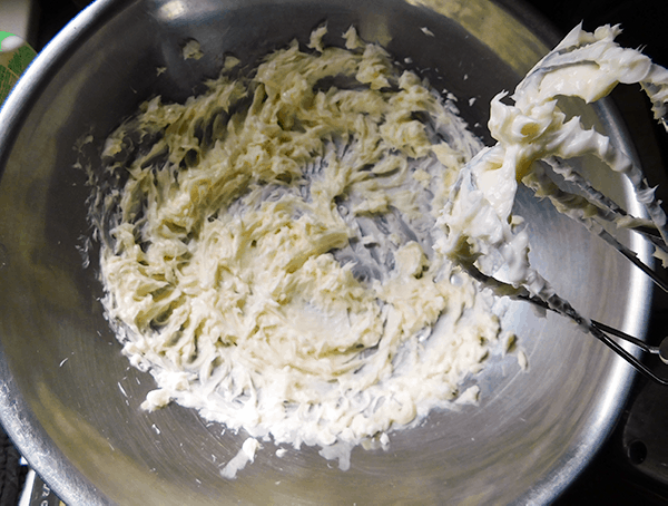 Butter and vegetable shortening mixed together to make filling in a silver bowl with beaters