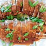 Sliced Asian Pork Tenderloin with sauce on a silver platter
