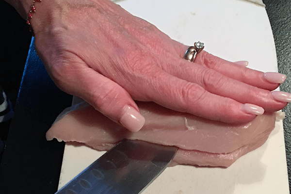 Cutting a pocket into chicken for insertion of a packet 