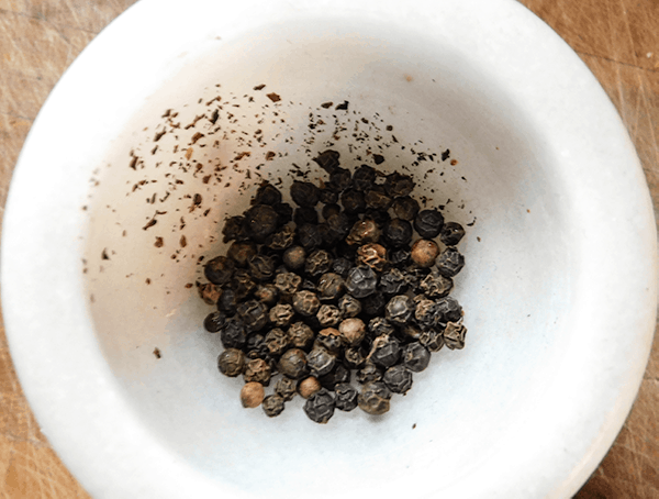 Peppercorns in a white mortar ready for crushing