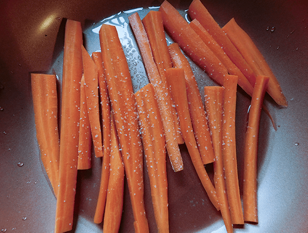 Sliced and peeled carrots in a pan ready to become Sweet and Spicy Carrots