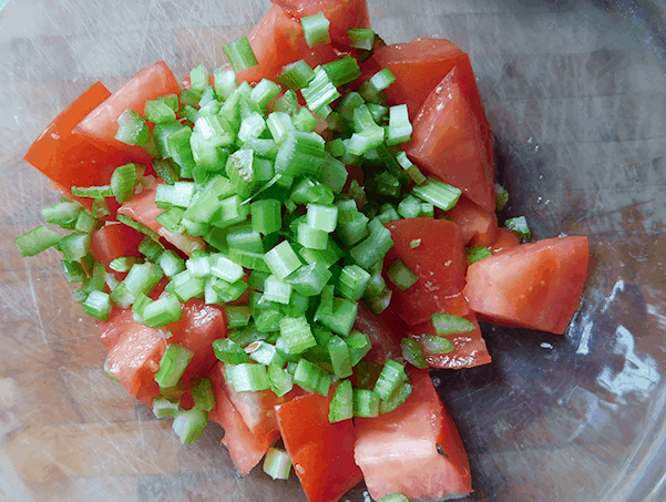 Chopped tomatoes and celery in a clear bowl
